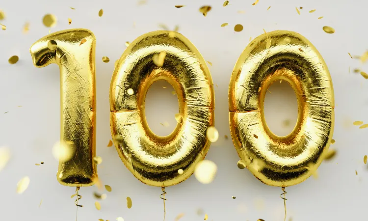 "100" spelled out in golden balloons